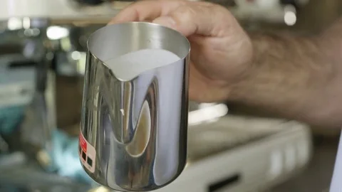 4K Close up hands of barista preparing coffee &amp; creating pattern in the froth Video stock 77004991