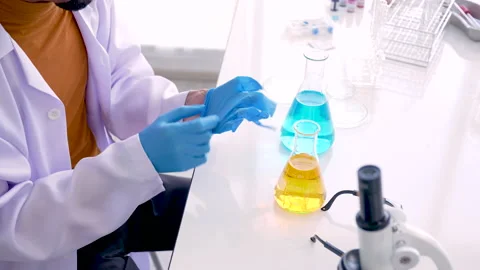 4K, Close Up Hands of a science teacher wearing blue gloves mixing lab Stock Footage 212670269