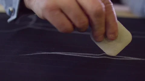 4K Close up on hands of a tailor working in his shop, drawing template on fabric Stock Footage 63227197