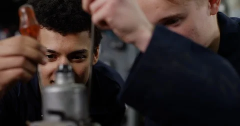 4K Close up happy apprentice mechanics in workshop rebuilding vehicle engine Video stock 112271295