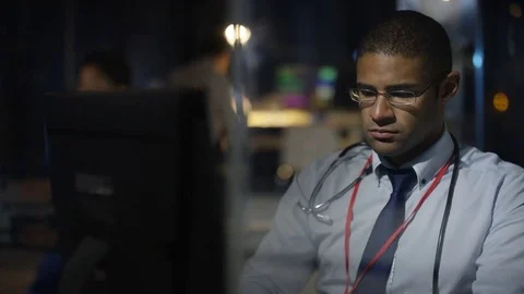 4K Close up hospital doctor on night shift working on computer. Stock Footage