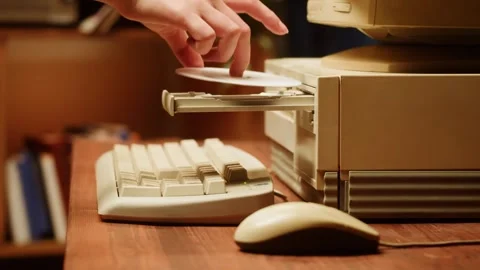 4K Close Up of Inserting Compact Disc CD into Vintage Computer Drive Stock Footage 328535951