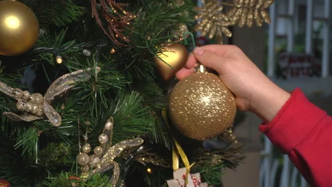 4K Close up of kid hands decorating Christmas tree with ball Stock Footage 144256450