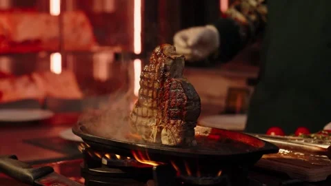 4K Close-up Large T-Bone Steak Sizzling Pan Restaurant Kitchen Stock Footage 330479544