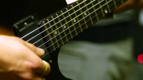 4k Close up of a man playing a guitar picking strings. Video stock 77443013