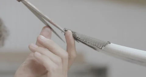 4K of close up of man precisely cutting fiberglass folded over surfboard edging Stock Footage 159820901