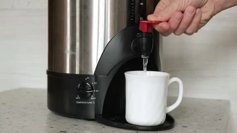 4K. Close-up of a man's hand pouring hot water into a white mug from a boiler. Stock-Footage 169639612