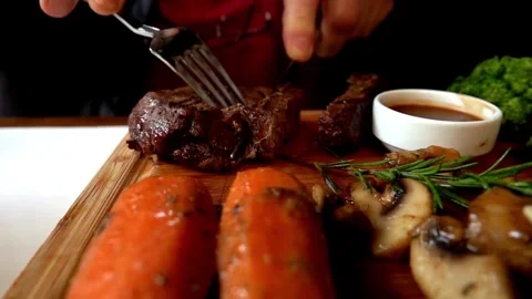 4K Close-up Person Cutting Cooked Beef Tenderloin Steak Wooden Board Video stock 330480628