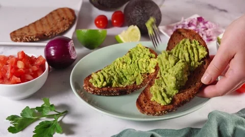 4K Close-up Person Preparing Garnishing Healthy Avocado Toast Stock Footage 330477922