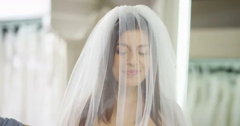 4K Close up portrait happy bride to be trying on her wedding gown in store Stock Footage