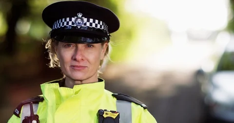 4K Close up portrait of smiling UK policewoman with blurred background Stock Footage 113266791