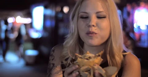 4K Close up pretty hip fun woman girl eating burger from food truck night Stock Footage 52931760