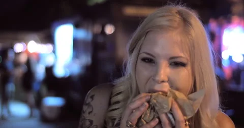 4K Close up pretty hip fun woman girl eating burger from food truck night V2 Stock Footage 52933366