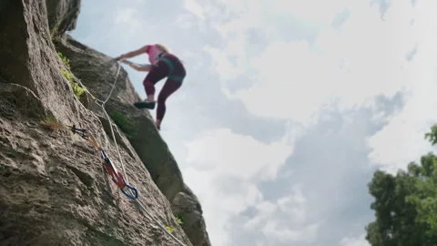 4K Close Up of Quickdraw and Rope with Blurred Female Climber on Rock Wall Stock-Footage 336464657