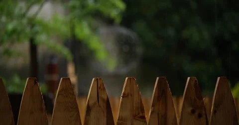 4K CLOSE UP RACK FOCUS OF FENCE TO BIRD FEEDER IN RAIN Stock Footage 131128272