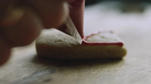 4K Close-up of Red Icing Piped onto a Holiday Cookie Stock Footage 342113543