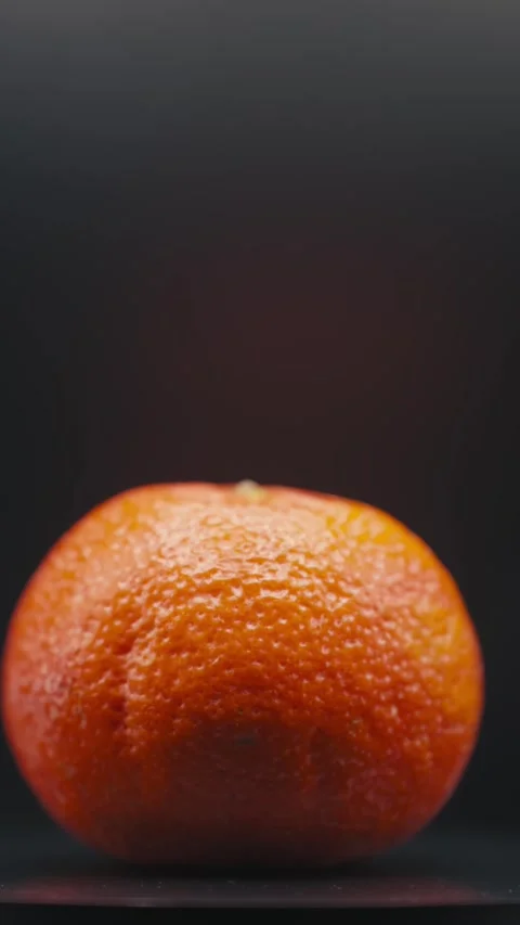 4k close up of Rotating Orange on Black Background Stock Footage 300108964