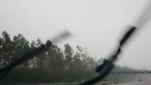 4K close-up shot of car windshield wipers in motion clearing heavy rain during Video stock 346405529
