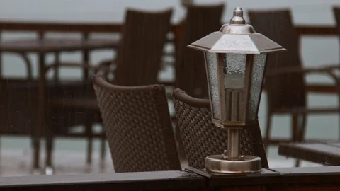 4K Close up shot how rain drops fall on the wooden table with table lamp Stock-Footage 99934567