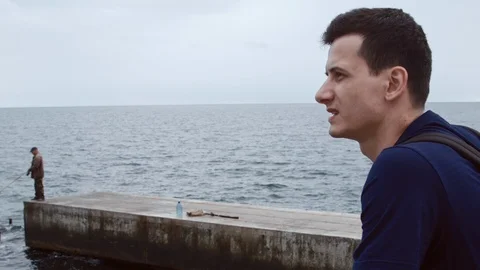 4K Close up shot of a man from side with the sea backround Vidéo 99932103