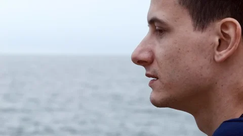 4K Close up shot of a man's face from side on the sea background Vidéo 99932045