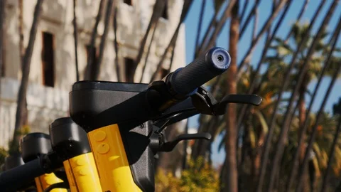 4k close up shot selective focus of handle bars of yellow shared scooters Stock Footage 123414699