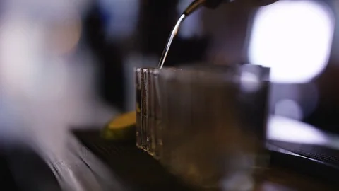 4K Close Up Of Unrecognizable Barman Pouring Alcohol Into Row Of Shot Glasses Stock Footage 75780599