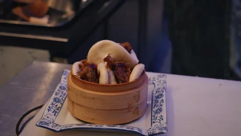 4K close up video chef plating duck bao buns with coriander in bamboo container Stock Footage 315990537