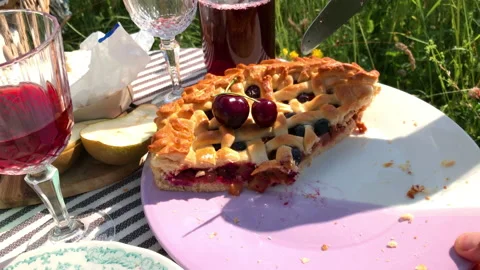 4K Close up video of cutting the cherry pie by man on the summer grass meadow. Stock-Footage 163465657