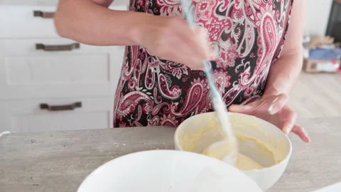 4K close-up video of dought being whisked in deep white bowl while making apple Vidéo 319295008