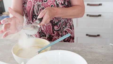 4K close-up video of dought being whisked in deep white bowl while making apple Stock Footage 329754943