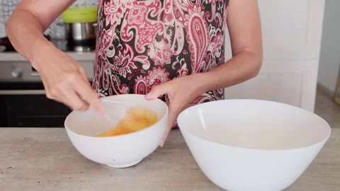 4K close-up video of eggs being whisked in a deep white bowl while making apple Stock-Footage 315822771