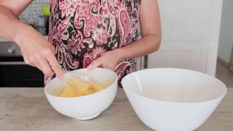 4K close-up video of eggs being whisked in a deep white bowl while making apple Video stock 320006161