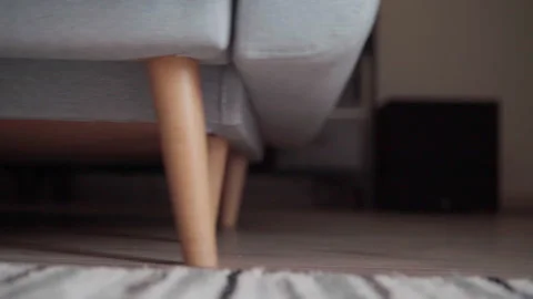 4K close-up video of gray sofa being pushied on laminate floor in modern living Stock Footage 318992388