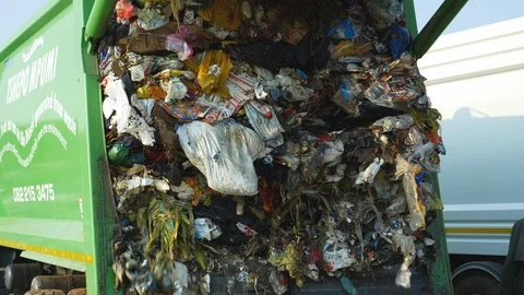 4K close-up view of trash being dumped by a garbage truck at a landfill dump Video stock 104703136