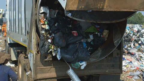 4K close-up view of trash being dumped by a garbage truck at a landfill dump Stock Footage 104703615