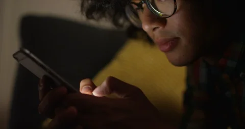 4K Close up young man staring at smartphone while texting at home in the dark Stock Footage 87130005