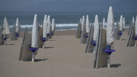 "4K closed umbrella and deck chairs on the beach" Stock Footage 90843594