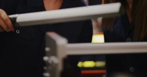 4K Closeup 2 beautiful mixed ethnicity female engineers checking factory machine Stock Footage 102026463