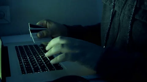4k closeup footage of hacker holding credit cards typing code on laptop. Man Stockbeeldmateriaal 88917932