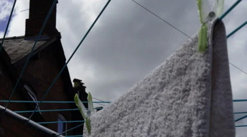 4K Closeup of hands hanging up laundry on a washing line outside with house Stock Footage 51842413