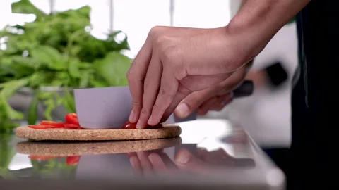4K closeup hands working in kitchen, junior chef chopping vegetables tomato.. Stock Footage 245129882