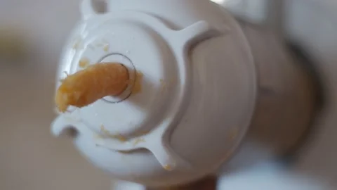 4K Closeup view of orange pulp emerging from auger juicer, making homemade juice Stock Footage 164084361