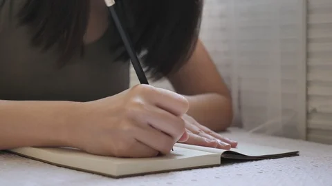 4K: Closeup at the woman's hand holding a black pencil Stock Footage 108715900