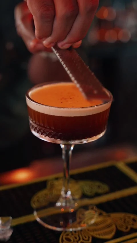 4K coffee bean garnish grated above espresso martini - vertical video Stock Footage 314682803