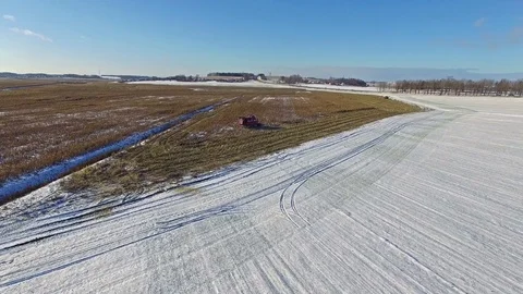 4K. Combine Harvester is working in the corn field after the First Snow! Aerial. 動画素材 69768543