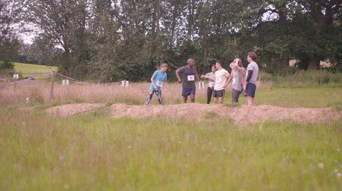 4K Competitive team in assault course race warming up at the starting line Stock Footage 65740943