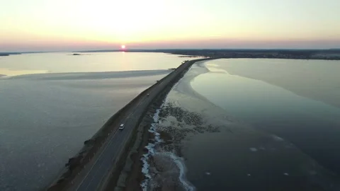4K Compilation Video. Flight over road in frozen lake on sunset, aerial view. Video stock 85601304