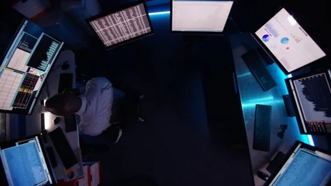 4K Computer expert working in a dark room surrounded by computer screens Video stock 73408726