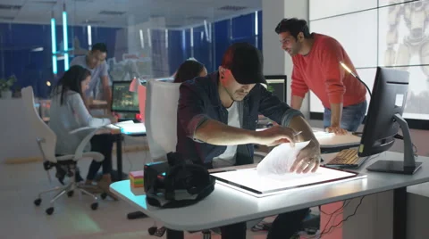 4K Computer game designer drawing at his desk with VR headset beside him Stock Footage 67903298